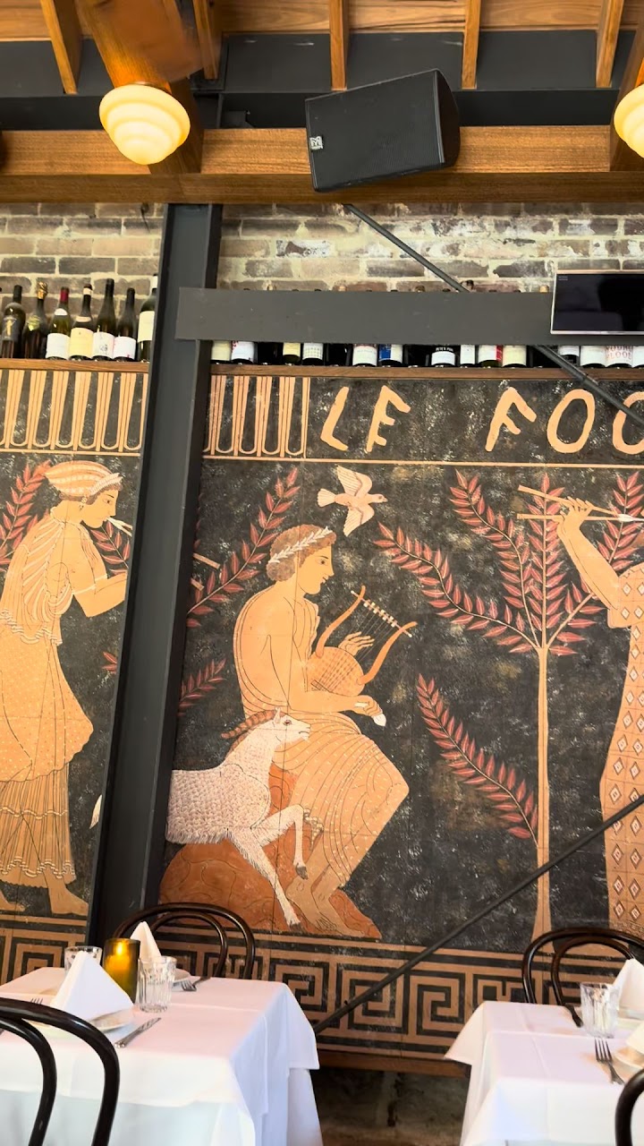 Le Foote dining room with Greek-style wall art and white tablecloths